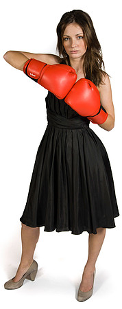 A brunette wearing a black evening dress and boxing gloves