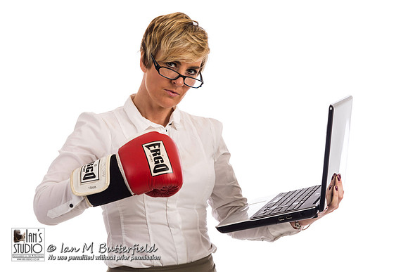 An angry business woman about to hit a laptop