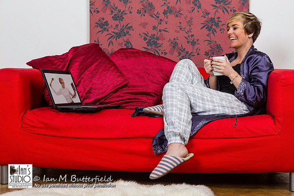 A woman watching a movie on her laptop on a sofa