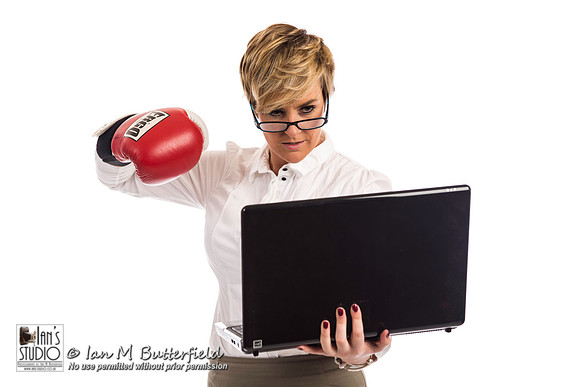 An angry business woman about to hit a laptop