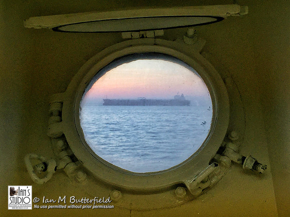 A container ship seen from a port hole