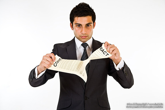 FA0718E-E08176 : A man in a suit tearing up a contract