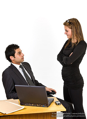 FA0718E-E08129 : A man and woman discussing data on a loptop in an office