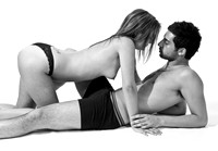 FA0718D-E08079-2 : A topless young woman crawls over a young man in his underwear.