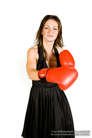FA0308A-E02261 : A brunette wearing a black evening dress and boxing gloves