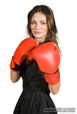 FA0308A-E02255 : A brunette wearing a black evening dress and boxing gloves