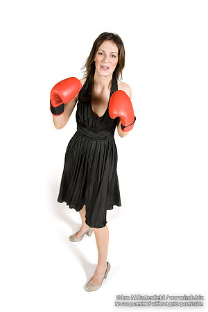 FA0308A-E02259 : A brunette wearing a black evening dress and boxing gloves