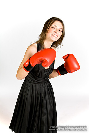 FA0308A-E02260 : A brunette wearing a black evening dress and boxing gloves