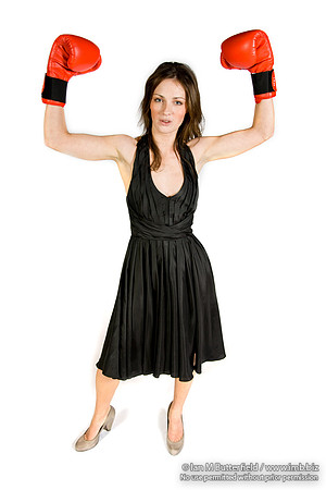 FA0308A-E02263 : A brunette wearing a black evening dress and boxing gloves