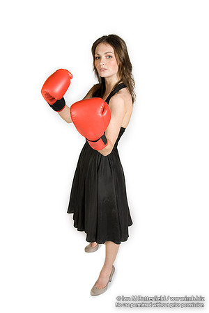 FA0308A-E02258 : A brunette wearing a black evening dress and boxing gloves