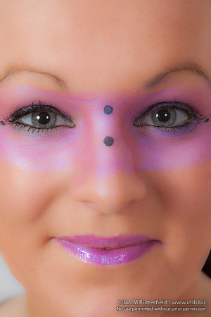 Close-up of a model with pink make-up round her eyes.