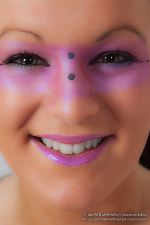 Close-up of a model with pink make-up round her eyes.