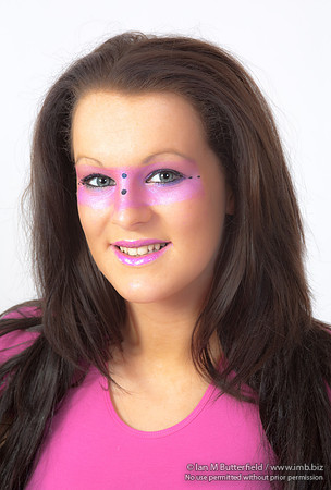 Brunette model with pink make-up round her eyes.
