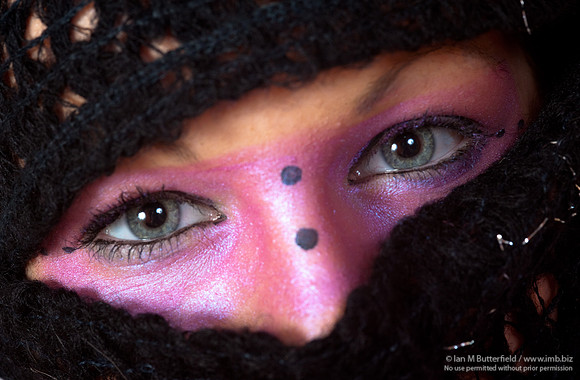 Pink make-up round the eyes and wearing a scarf