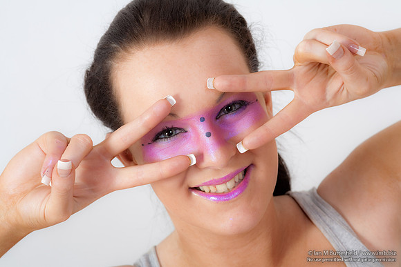 Brunette model with pink make-up round her eyes.