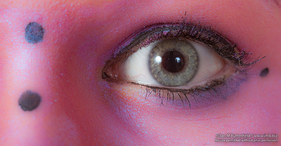 Close-up of a model with pink make-up round her eyes.