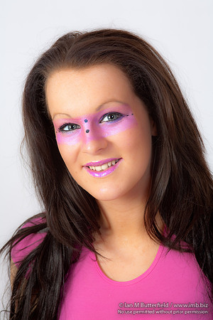 Brunette model with pink make-up round her eyes.