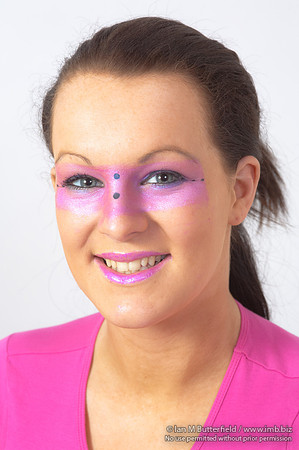 Brunette model with pink make-up round her eyes.