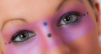 Close-up of a model with pink make-up round her eyes.