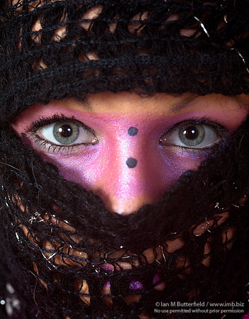 Pink make-up round the eyes and wearing a scarf