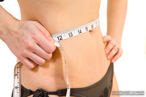 FA0403B-E03629 : Young, slim woman measures her waist