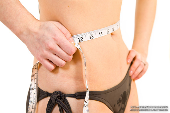 FA0403B-E03630 : Young, slim woman measures her waist