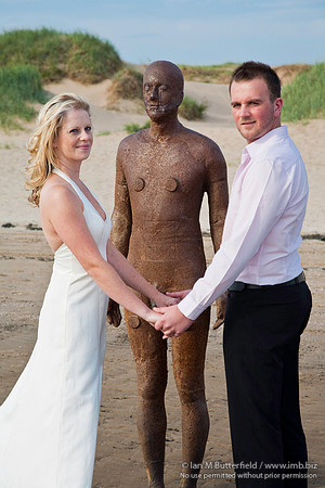 Wedding couple with one of Antony Gormley's statues.