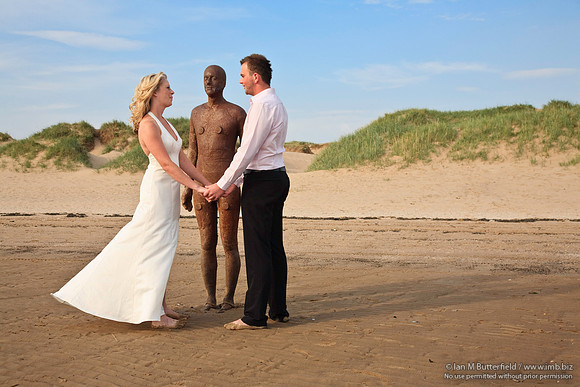 Wedding couple with one of Antony Gormley's statues.