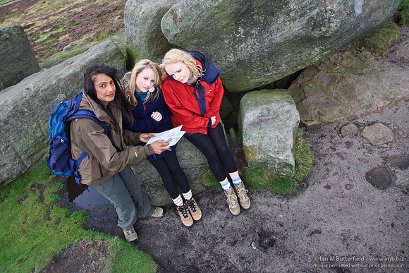 FB0902A-E05259 : Three walkers consult a map while walking on the hills.
