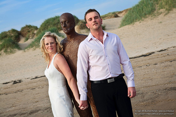 Wedding couple with one of Antony Gormley's statues.