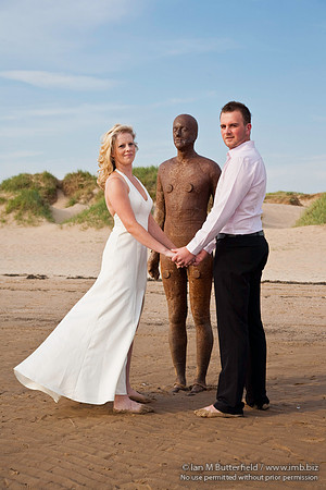 Wedding couple with one of Antony Gormley's statues.