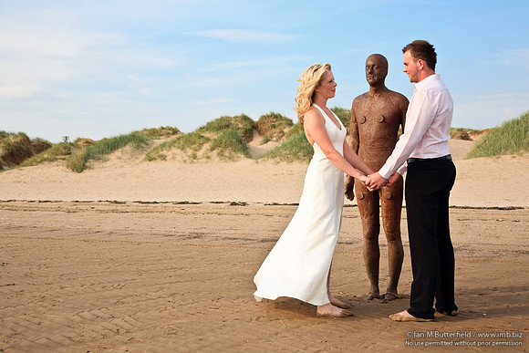 Wedding couple with one of Antony Gormley's statues.