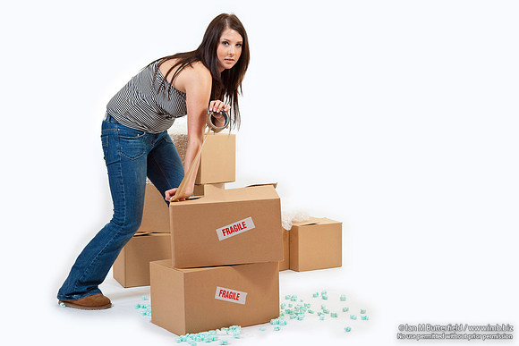 Attractive young woman sealing up storeage boxes