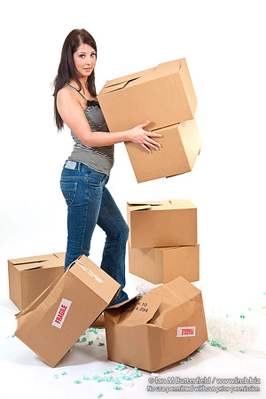 Attractive young woman with carrying and droping storeage boxes