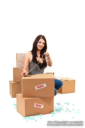 Attractive young woman sealing up storeage boxes