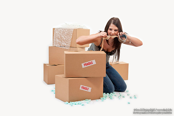 Attractive young woman sealing up storeage boxes